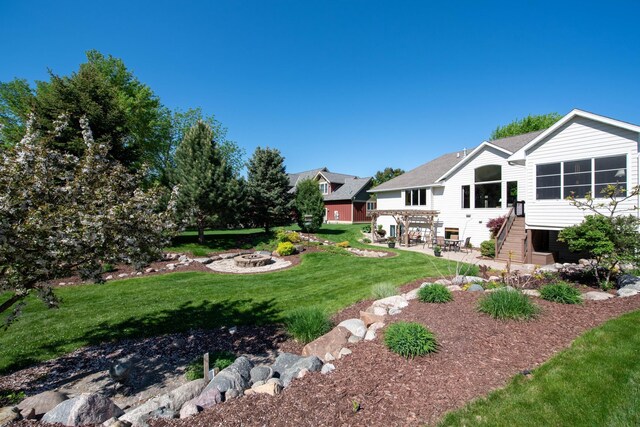 26 Deerwood Ct, North Mankato, MN 56003 - view of green lawn featuring a fire pit, a patio area, and stairway
