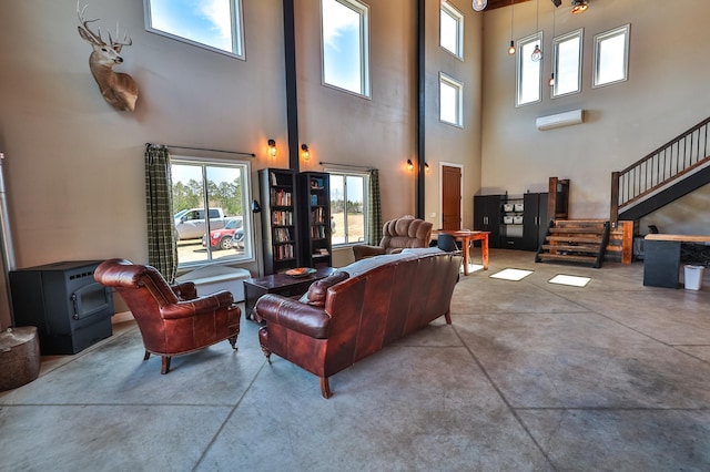 living room with finished concrete flooring, a high ceiling, and stairway