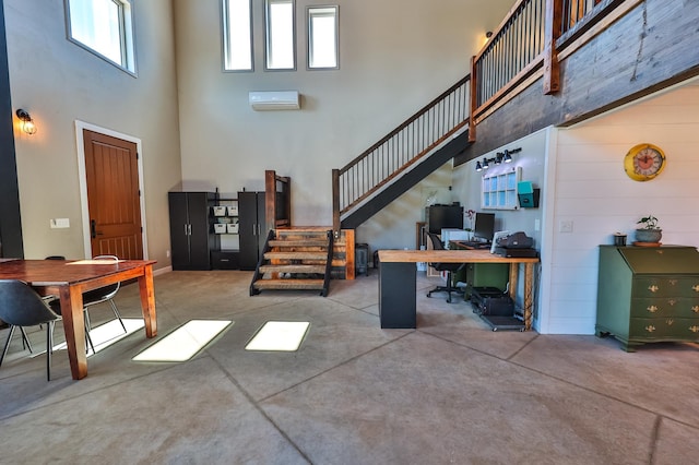 living room featuring a high ceiling, concrete floors, and a wealth of natural light