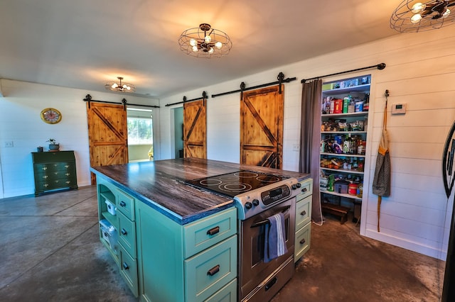 kitchen with dark countertops, a barn door, green cabinetry, electric stove, and concrete floors