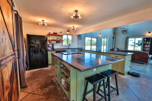 kitchen featuring black fridge with ice dispenser, open shelves, finished concrete flooring, a chandelier, and green cabinets