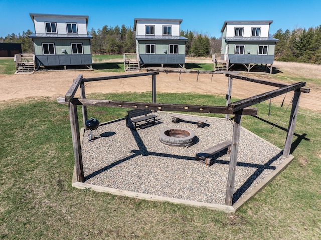 surrounding community with a yard and a fire pit