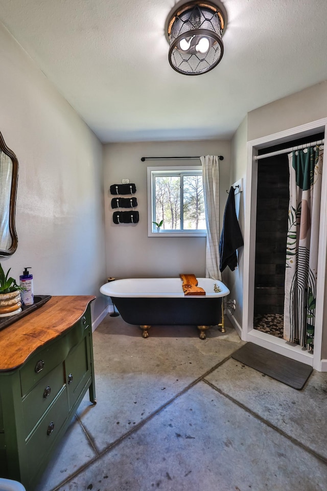 bathroom featuring a freestanding tub, baseboards, a textured ceiling, concrete floors, and a stall shower