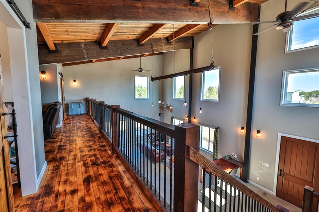 hallway featuring a high ceiling, beam ceiling, and a wealth of natural light
