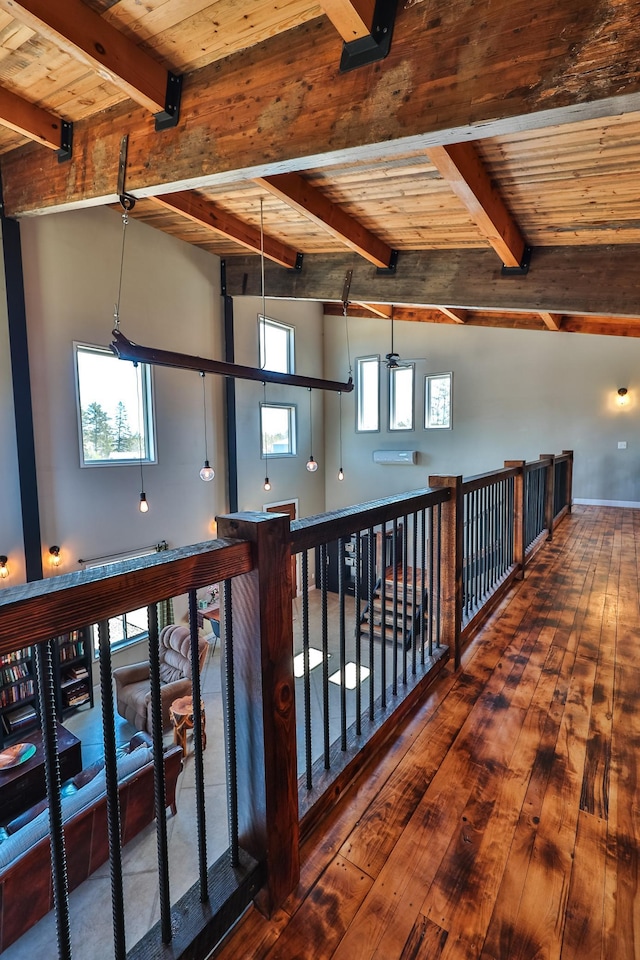 corridor featuring beamed ceiling, wooden ceiling, plenty of natural light, and wood-type flooring