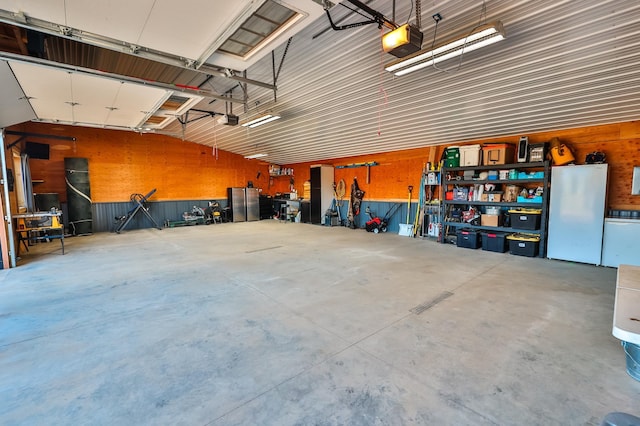 garage featuring freestanding refrigerator and a garage door opener
