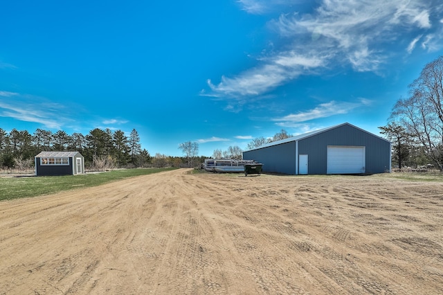 view of yard featuring a detached garage and an outdoor structure