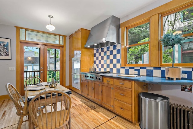 3622 Pleasant Ave, Minneapolis, MN 55409 - kitchen with wall chimney exhaust hood, stainless steel gas stovetop, backsplash, double oven, and dark countertops