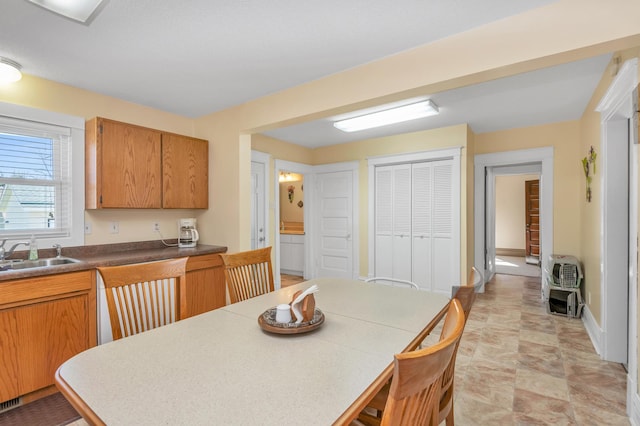 dining room with baseboards, stone finish flooring, and heating unit