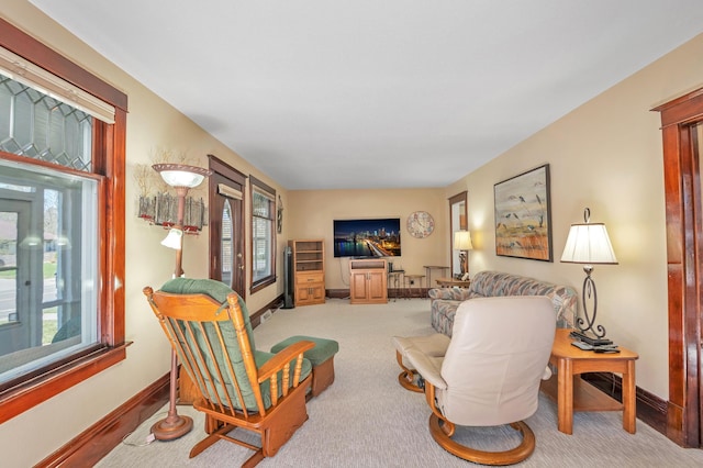 carpeted living area with baseboards and plenty of natural light