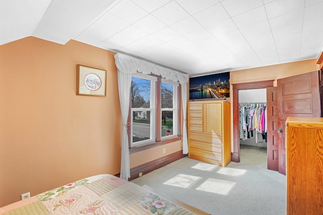 carpeted bedroom featuring a closet, lofted ceiling, and a spacious closet