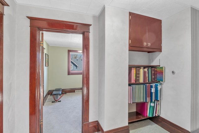 hallway with carpet flooring and baseboards