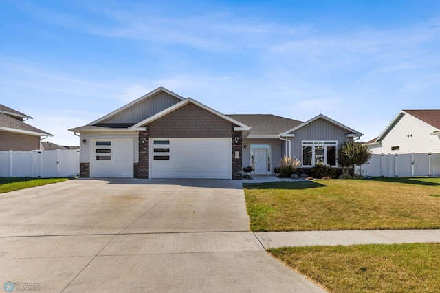 view of front facade with an attached garage, a front lawn, fence, and concrete driveway