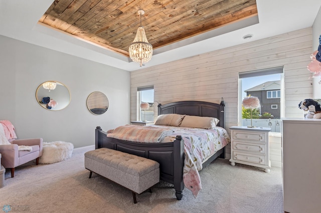 carpeted bedroom featuring wood ceiling, a tray ceiling, an inviting chandelier, and wood walls