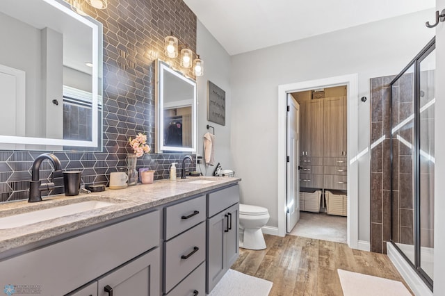 full bath with a shower stall, wood finished floors, and a sink