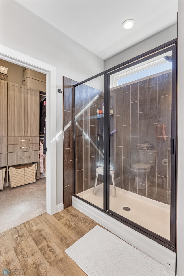 full bath featuring wood finished floors and a stall shower