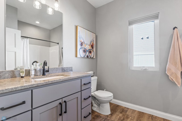 full bathroom featuring toilet, baseboards, wood finished floors, curtained shower, and vanity