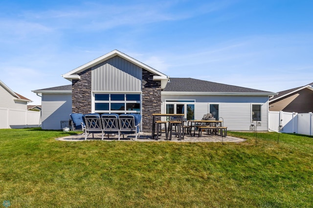 rear view of property with a fenced backyard, a patio area, and a lawn