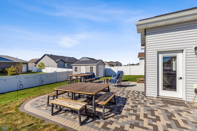 view of patio / terrace with outdoor dining space, a fenced backyard, an outdoor structure, and a residential view