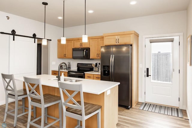 kitchen with stainless steel fridge, light countertops, light wood-type flooring, a sink, and black / electric stove