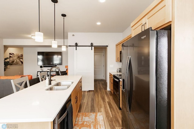 kitchen featuring wood finished floors, dishwashing machine, fridge with ice dispenser, black range with electric stovetop, and a sink