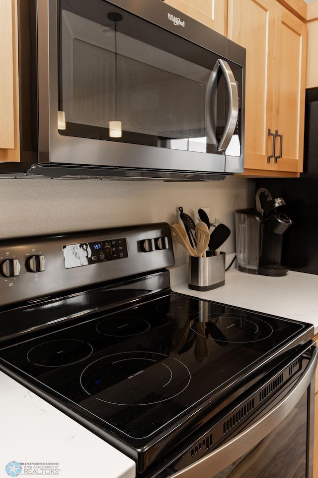 kitchen with light brown cabinetry, stainless steel appliances, and light countertops