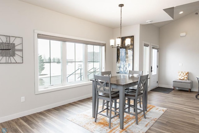 dining room with baseboards, a notable chandelier, and wood finished floors