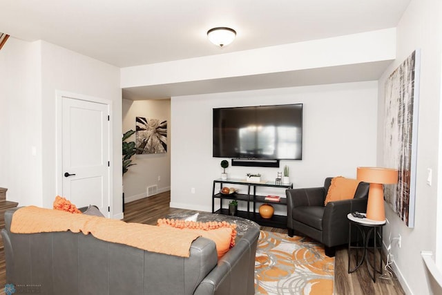 living area with baseboards, wood finished floors, and visible vents