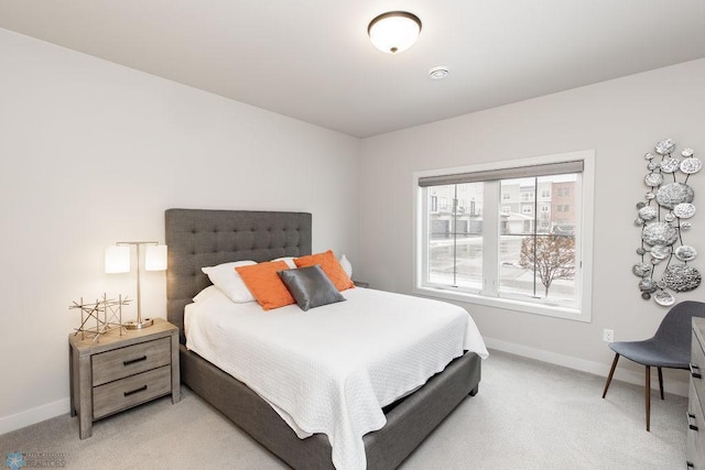bedroom with light colored carpet and baseboards
