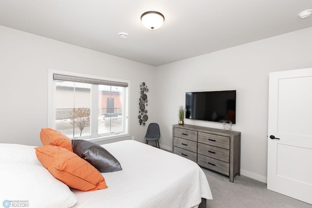 bedroom featuring light colored carpet and baseboards