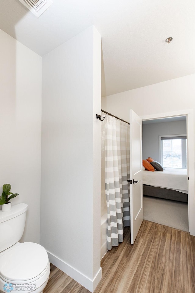 full bath with toilet, baseboards, wood finished floors, ensuite bathroom, and visible vents