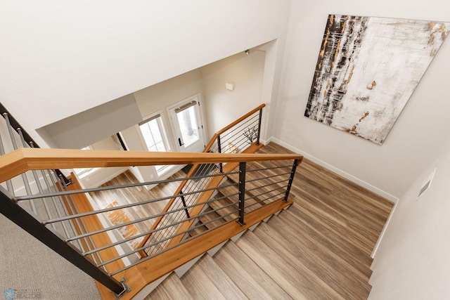 staircase with baseboards and wood finished floors