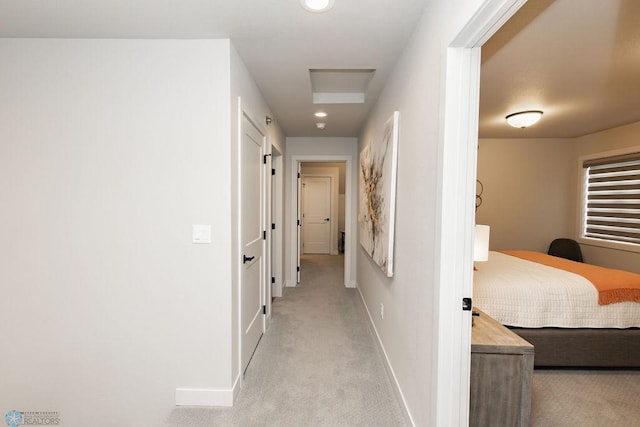 corridor featuring baseboards, recessed lighting, and light colored carpet