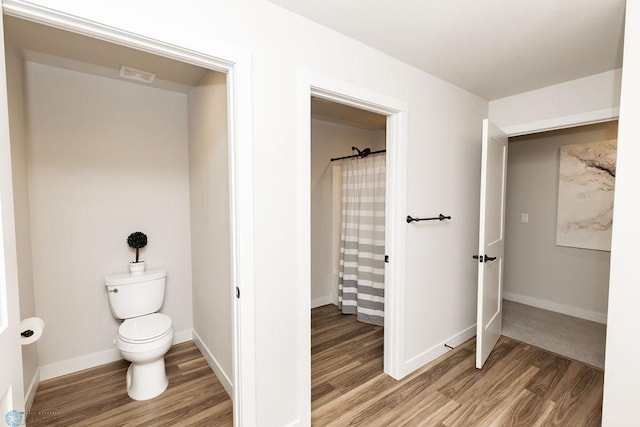 full bath with baseboards, toilet, wood finished floors, and visible vents