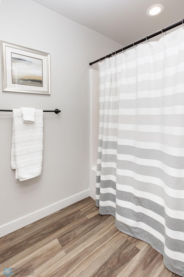 bathroom featuring baseboards, recessed lighting, wood finished floors, and curtained shower