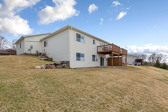 rear view of house featuring a wooden deck and a lawn