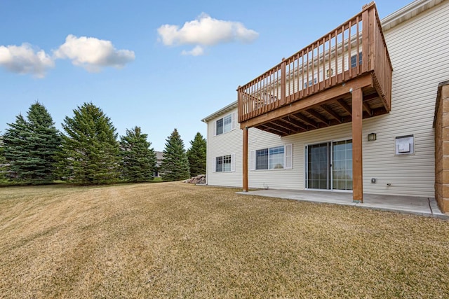back of property with a patio area, a wooden deck, and a yard