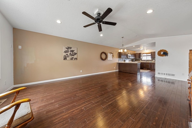 living room featuring a textured ceiling, ceiling fan, baseboards, lofted ceiling, and dark wood-type flooring