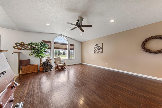 interior space featuring a ceiling fan, dark wood-style floors, a textured ceiling, and vaulted ceiling