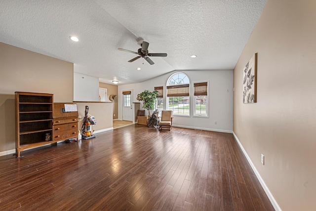 living room featuring ceiling fan, baseboards, wood finished floors, and a textured ceiling