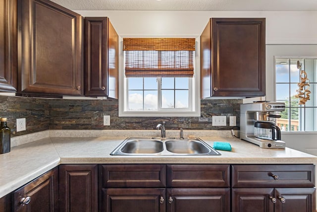 kitchen with light countertops, dark brown cabinets, and a sink