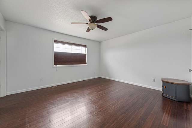 unfurnished room with baseboards, a ceiling fan, and dark wood-type flooring