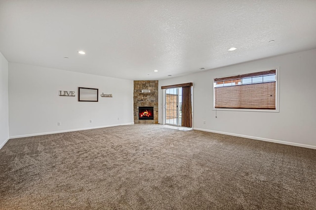 unfurnished living room with recessed lighting, baseboards, a fireplace, a textured ceiling, and carpet flooring
