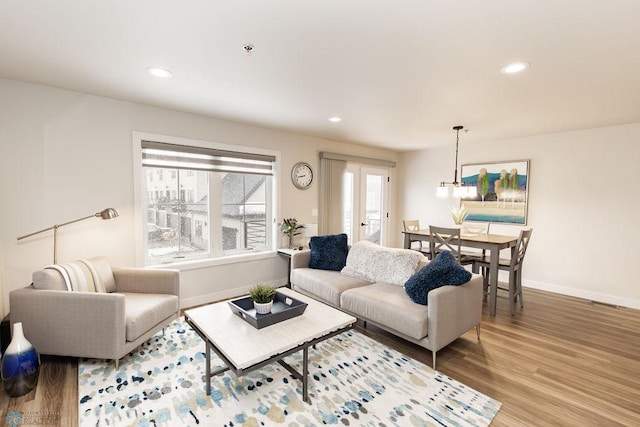 living room with baseboards, recessed lighting, and wood finished floors