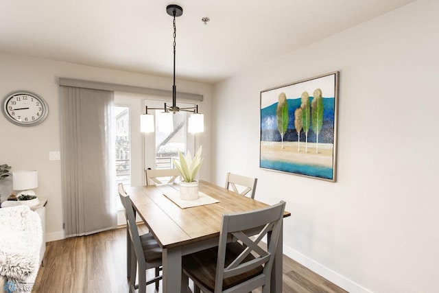 dining space with baseboards and wood finished floors