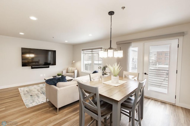 dining room featuring baseboards, recessed lighting, light wood-style flooring, and a chandelier