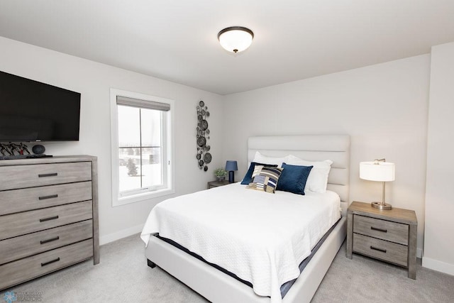 bedroom featuring baseboards and light carpet