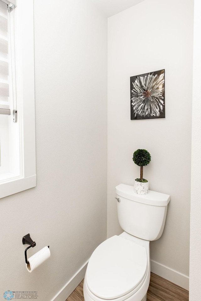 bathroom featuring toilet, baseboards, and wood finished floors