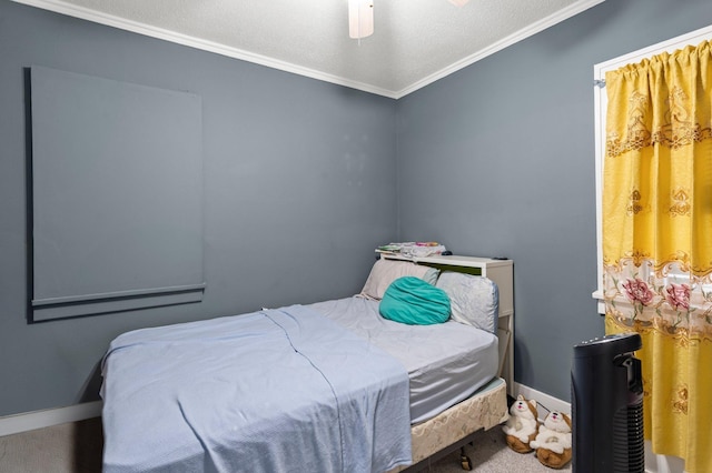 carpeted bedroom with ceiling fan, baseboards, and ornamental molding