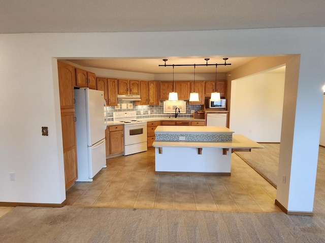 2155 6th Ln SE Unit 301, Cambridge, MN 55008 - kitchen with white appliances, under cabinet range hood, light countertops, a center island, and backsplash
